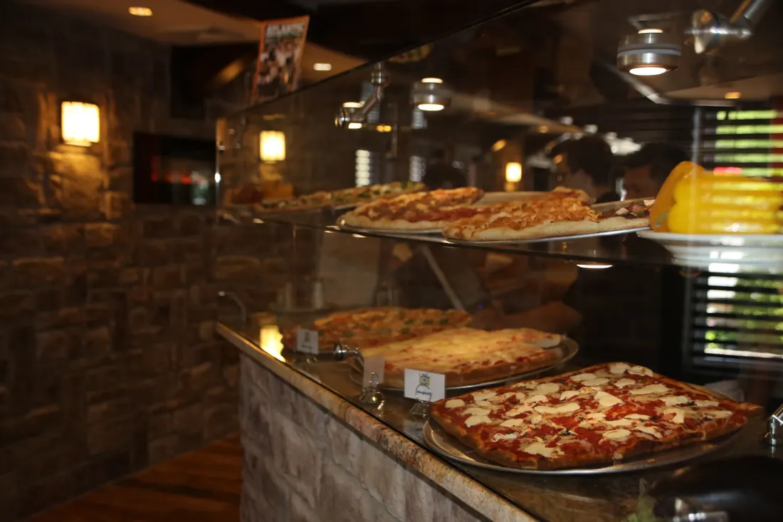 Brick-oven pizzas on the counter at Little Italy